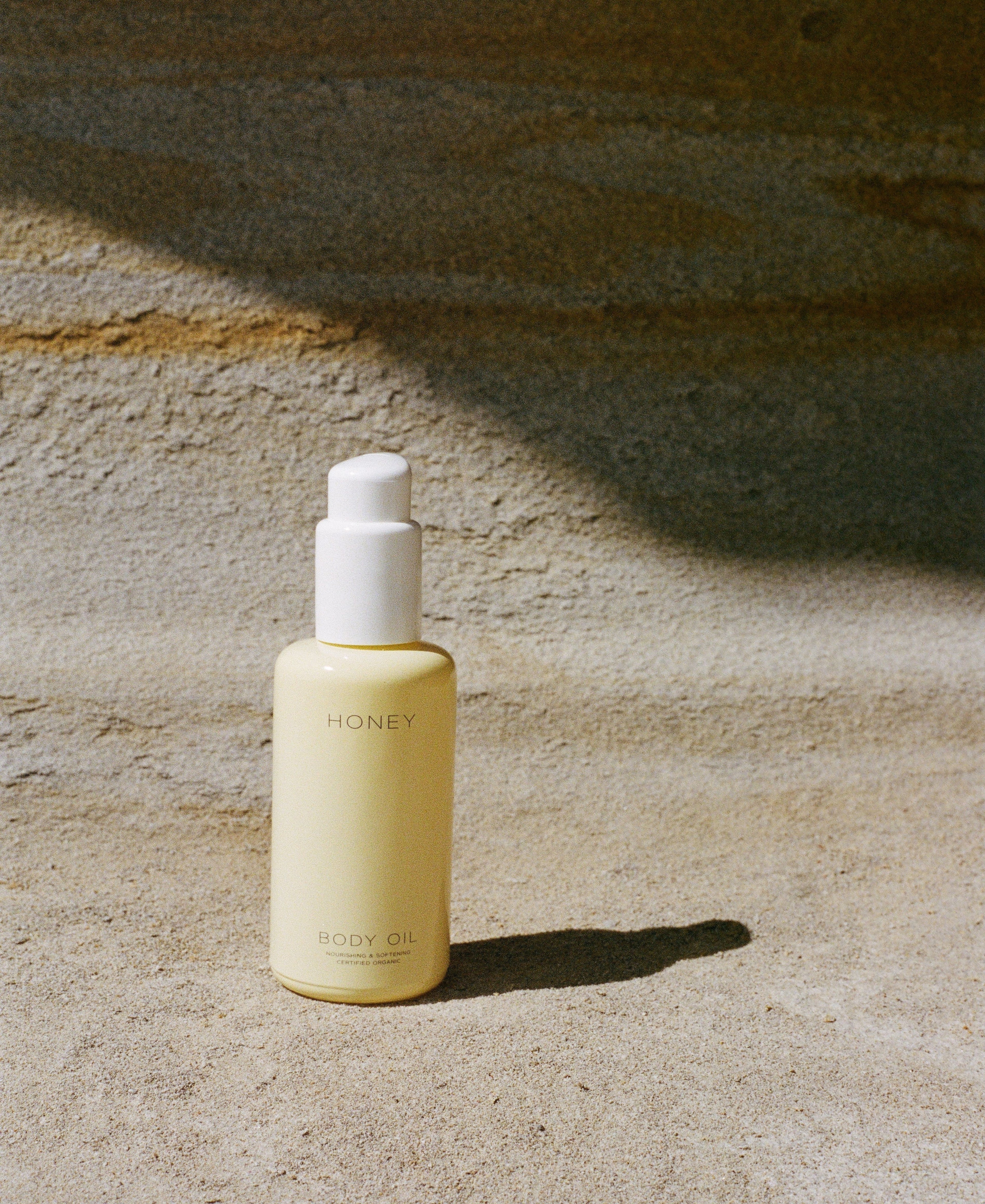 Naturlig parfumefri hudpleje kropsolie i gul flaske med hvid låg - clean skincare