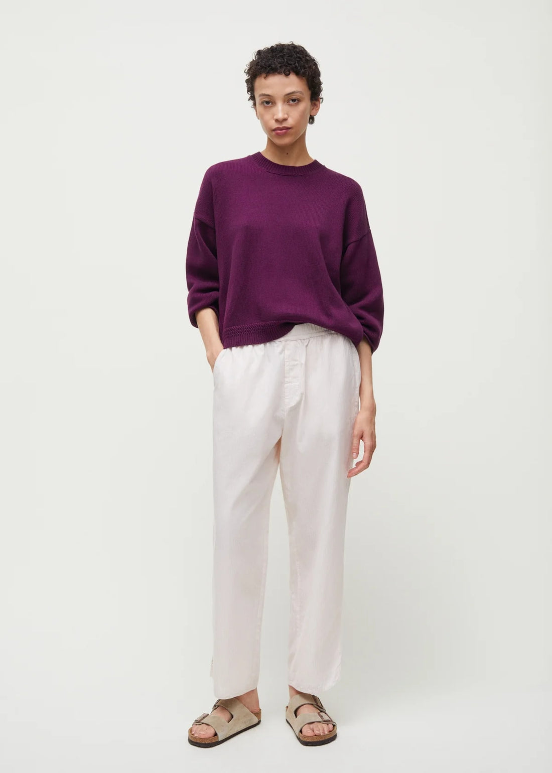 Kvinde i creme hvide pyjamasbukser i bomuld fra Aiayu og lilla oversized sweater