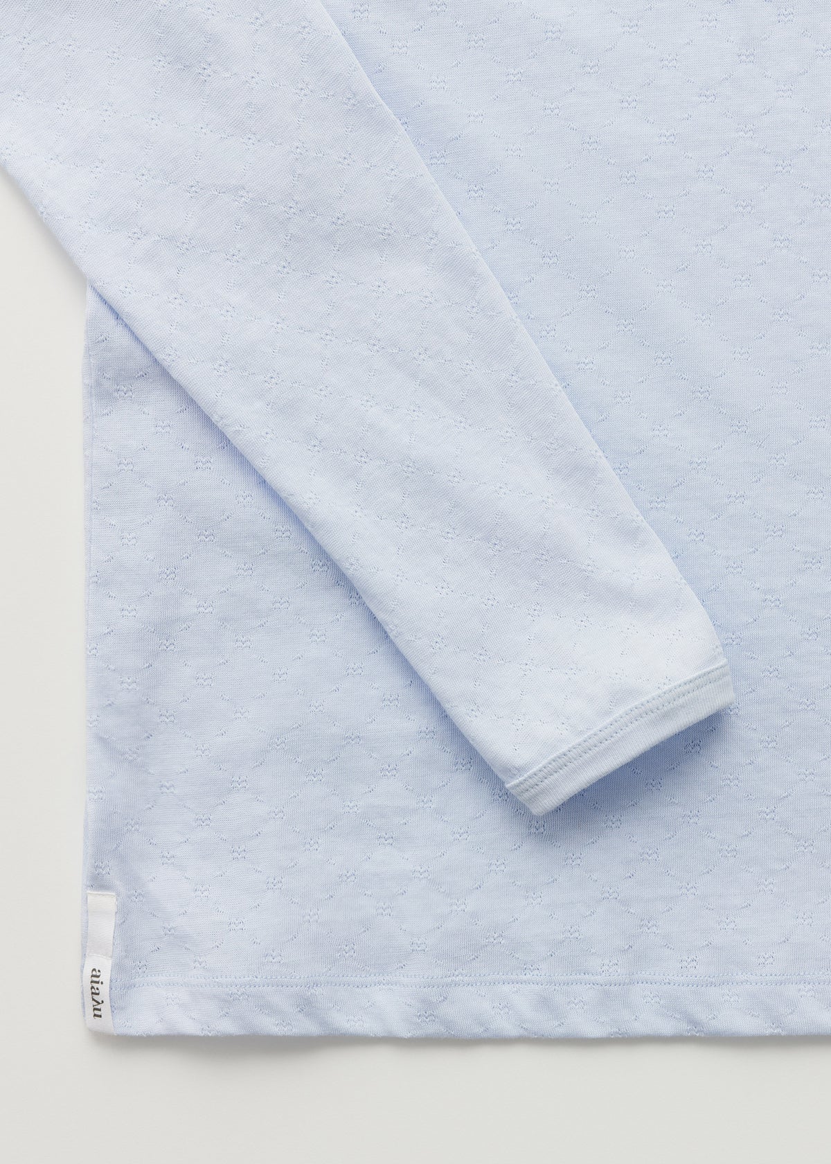 Detalje af hjørne og ærme af lyseblå bluse fra Aiayu.
