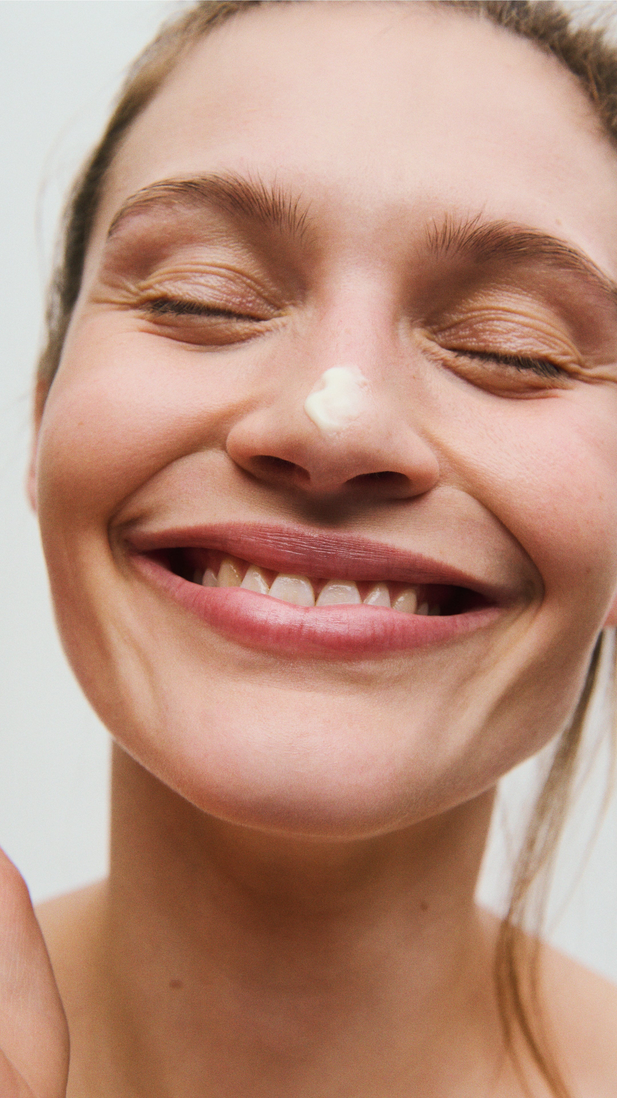 Kvinde med parfumefri naturlig ansigtscreme på næsen