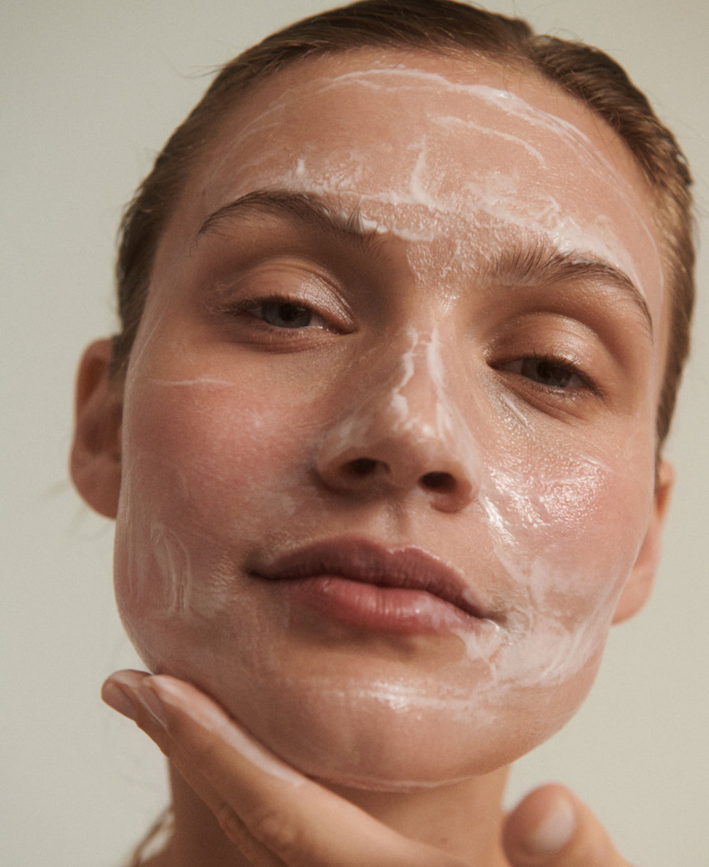 Kvinde med naturlig og parfumefri cleanser i ansigtet