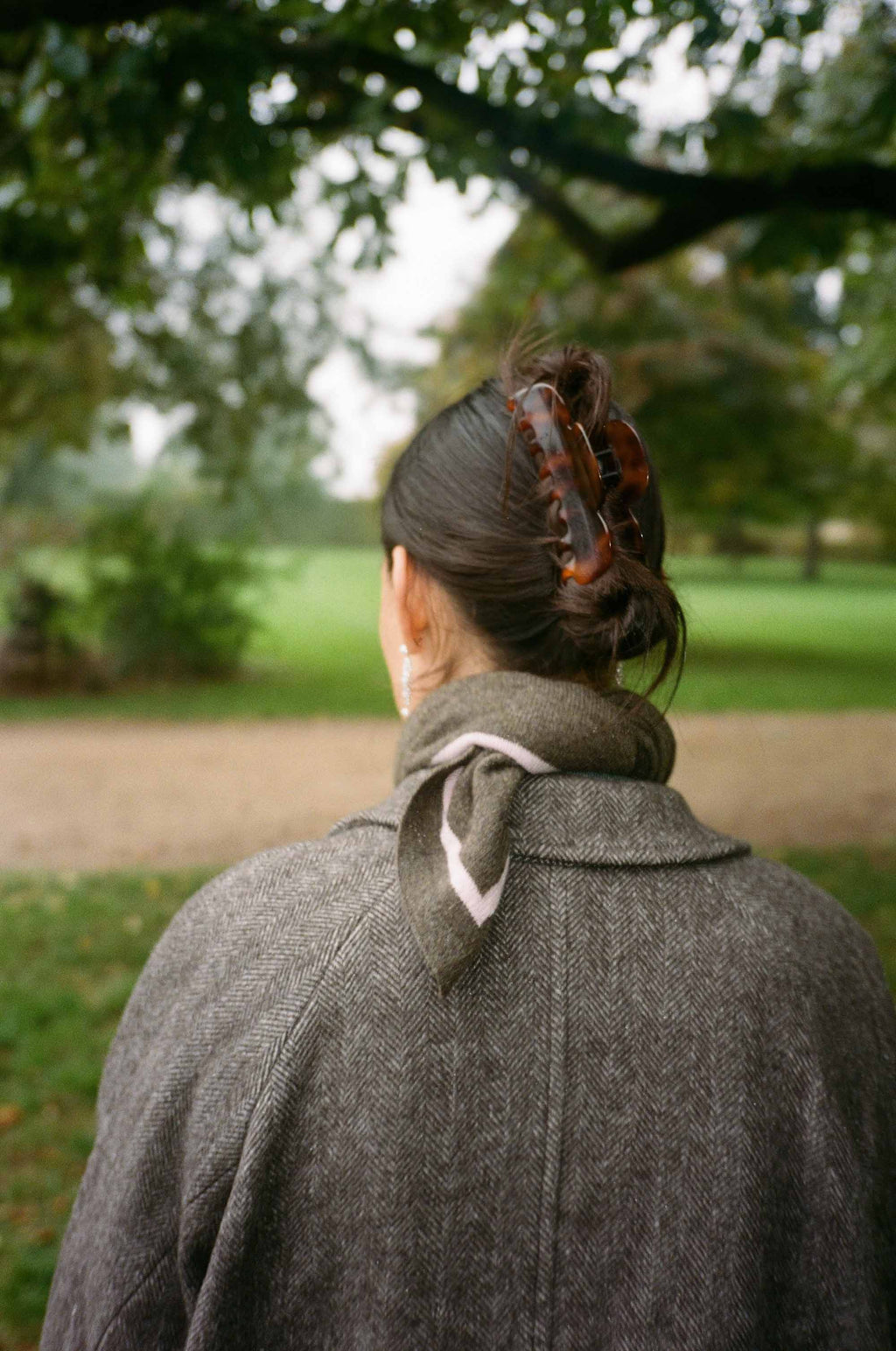 Kvinde i brun frakke og brunt og pink kashmirtørklæde