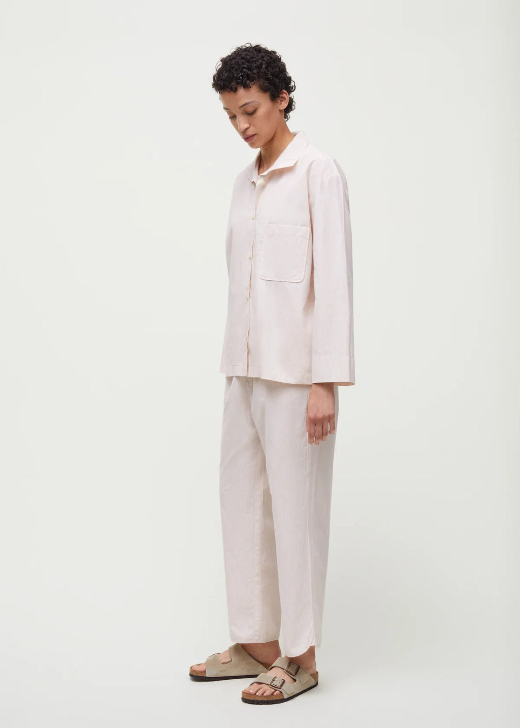 Kvinde i cremme hvid pyjamas og hjemmesko